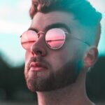 close-up photography of man wearing red lens sunglasses
